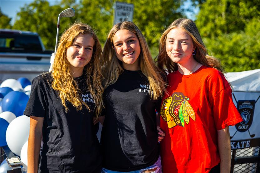 Three students smile